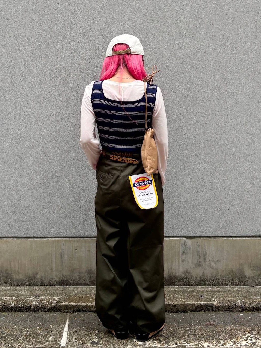 ベージュ系のショルダーバッグ、グリーン系のチノパンツ、ベージュ系のモカシン/デッキシューズを着用したレディースの春コーディネートの4枚目の写真