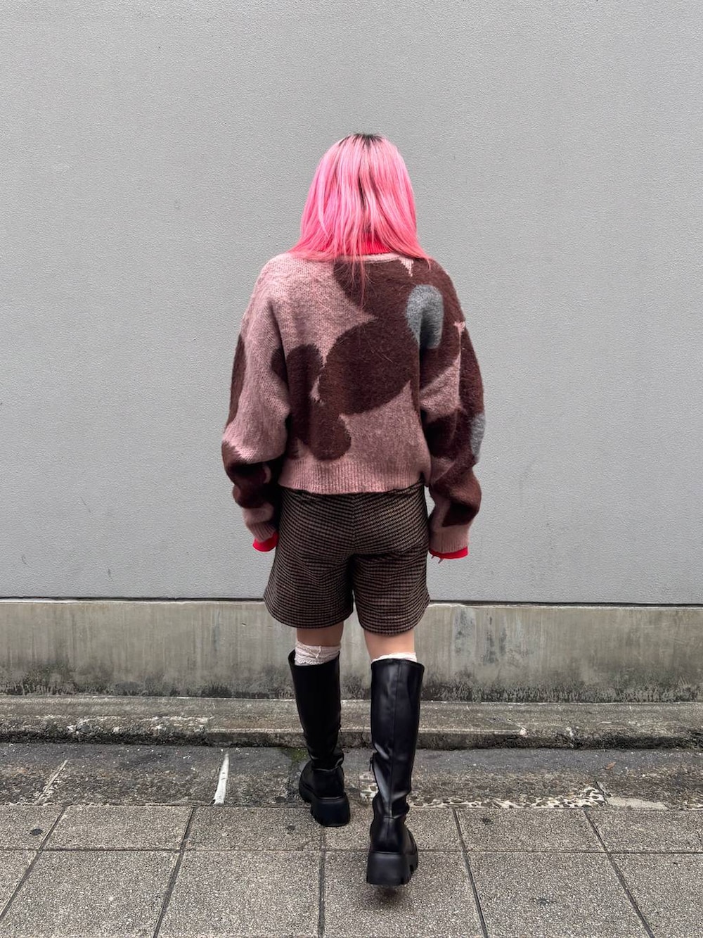 ブラック系のブーツ、ピンク系のニット/セーター、レッド系のニット/セーターを着用したレディースの冬コーディネートの2枚目の写真