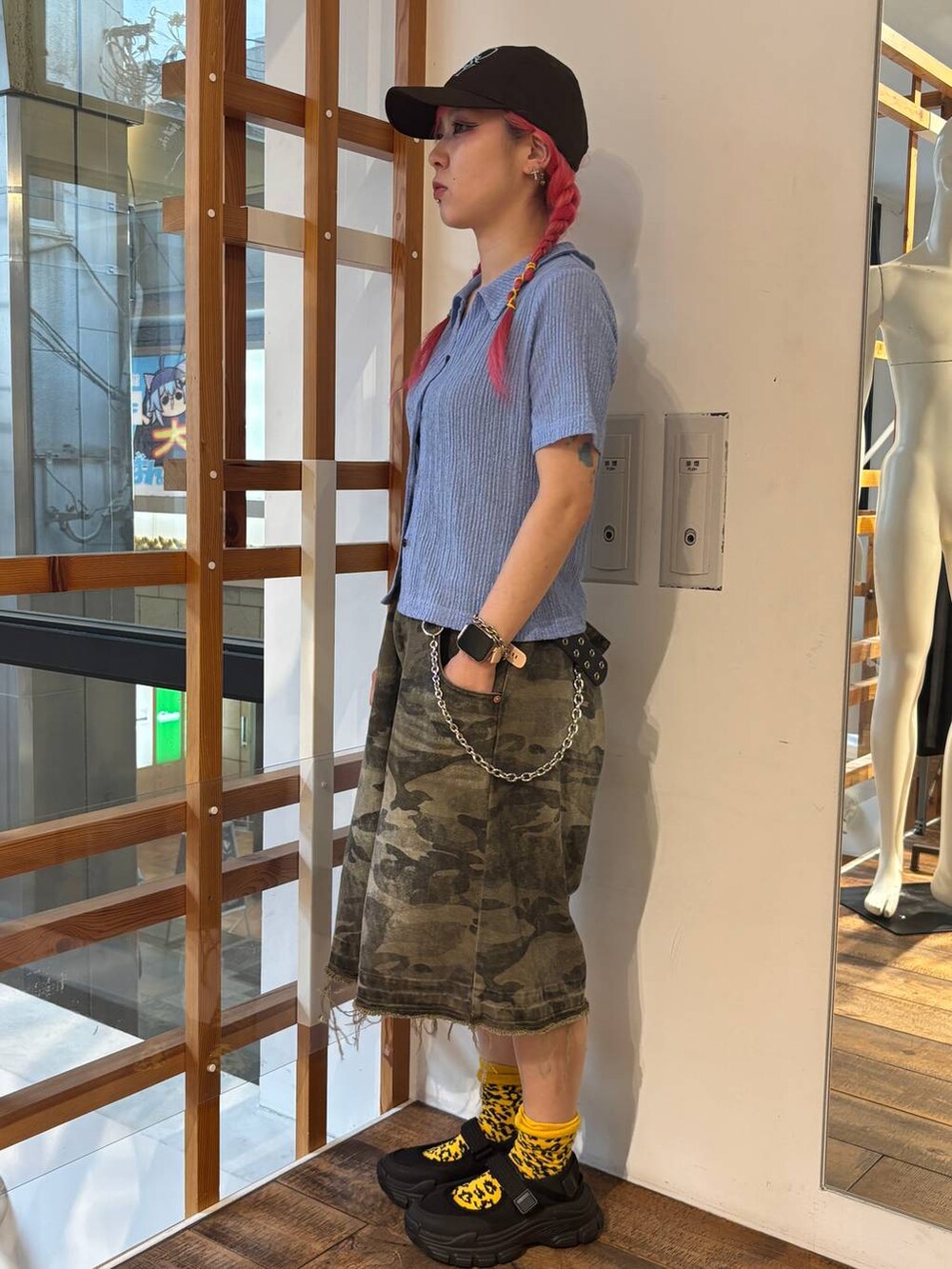 グリーン系のデニムパンツ、ブルー系のポロシャツ、ブラック系のタンクトップを着用したレディースの夏コーディネートの5枚目の写真