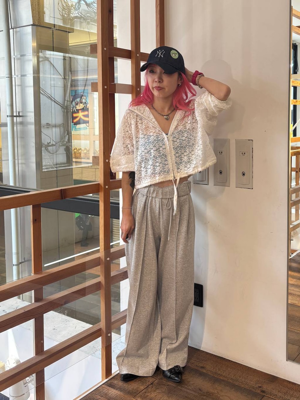 ホワイト系のパーカー、グレー系のスウェットパンツ、ブルー系のキャップを着用したレディースの夏コーディネートの7枚目の写真