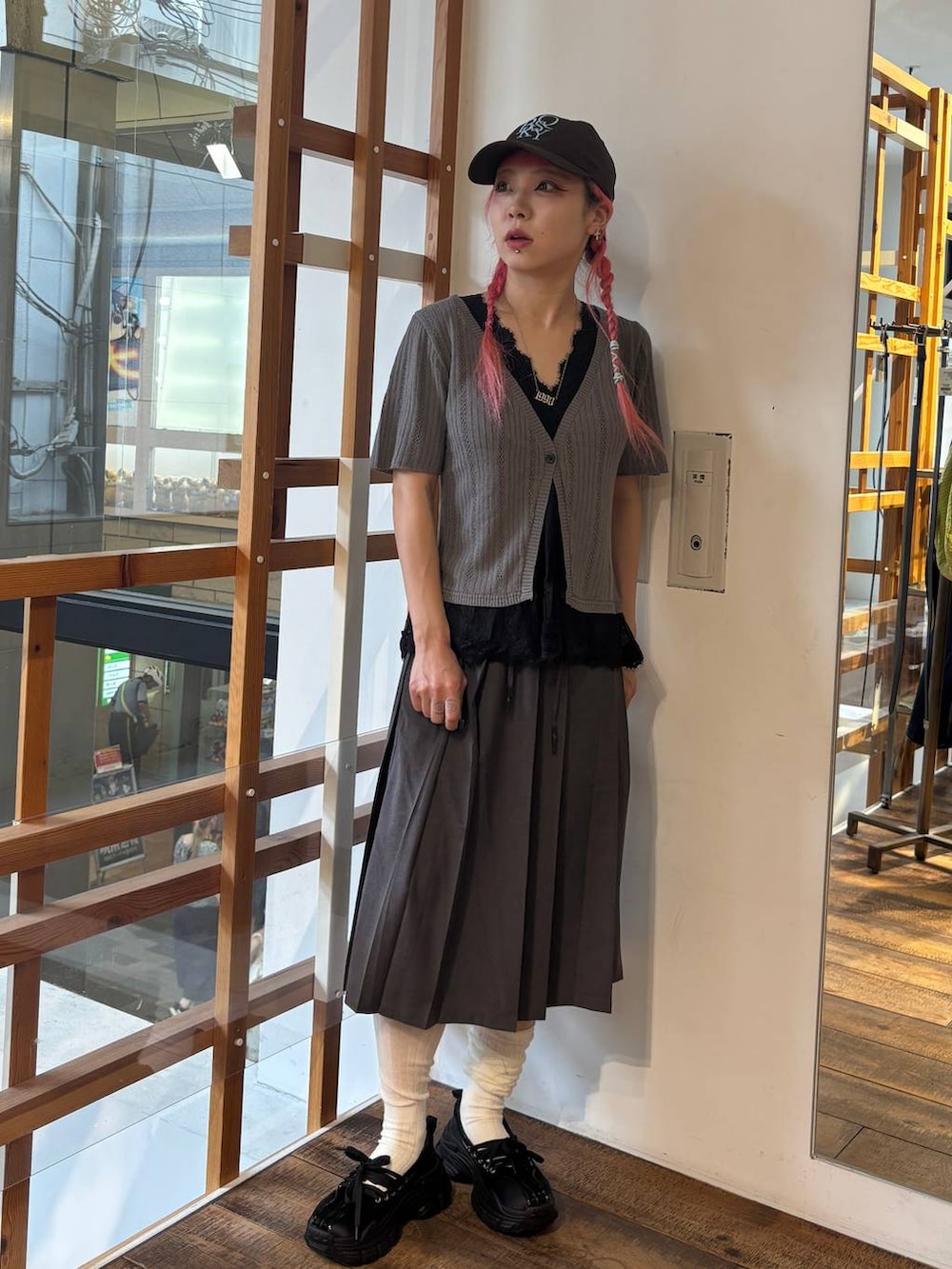 ブラック系のスリッポン、グレー系のTシャツ/カットソー、グレー系のスカートを着用したレディースの夏コーディネートの3枚目の写真