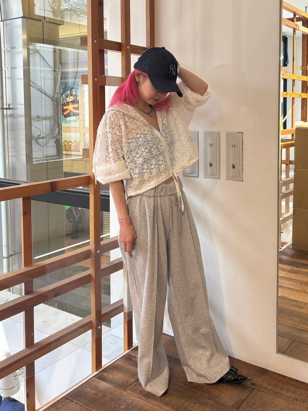 ホワイト系のパーカー、グレー系のスウェットパンツ、ブルー系のキャップを着用したレディースの夏コーディネートの2枚目の写真