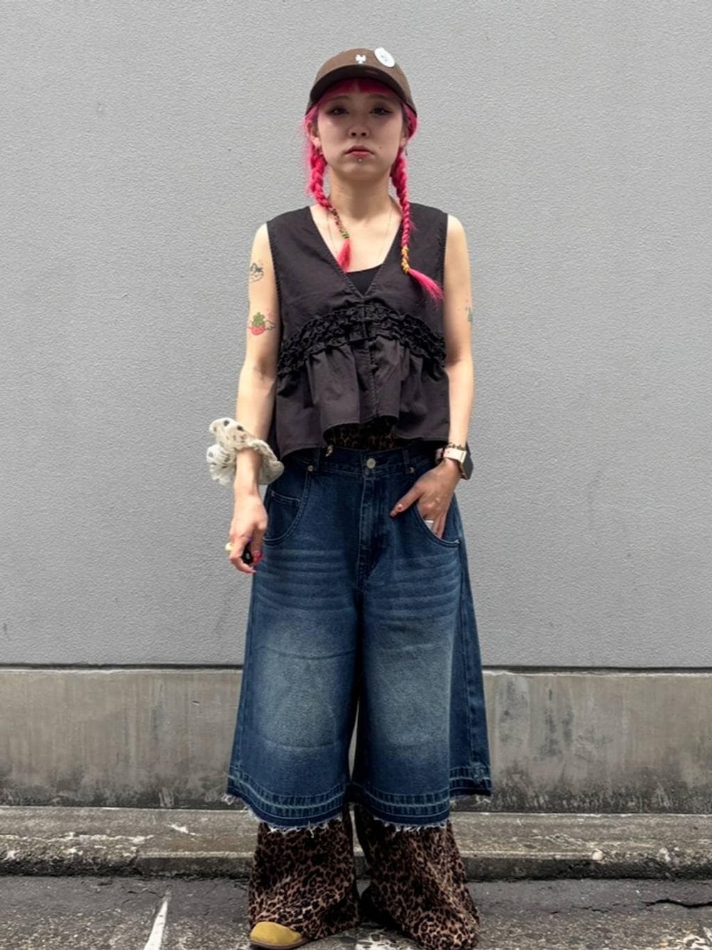 ブルー系のデニムパンツ、ブラック系のタンクトップ、ブラック系のベストを着用したレディースの夏コーディネートの2枚目の写真