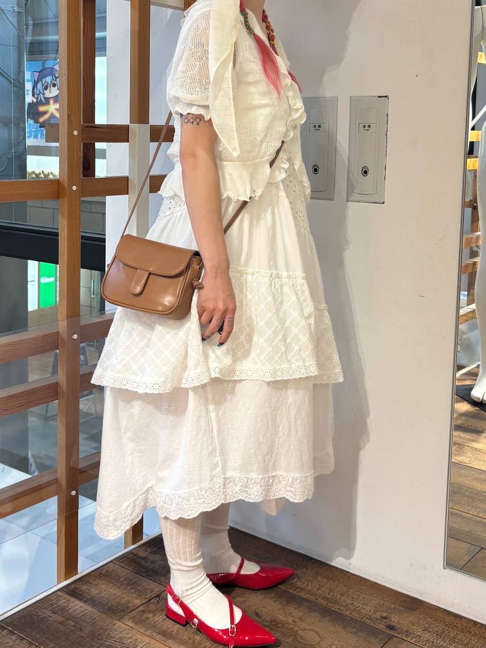 ホワイト系のスカート、レッド系のパンプス、ホワイト系のカーディガン/ボレロを着用したレディースの夏コーディネートの3枚目の写真
