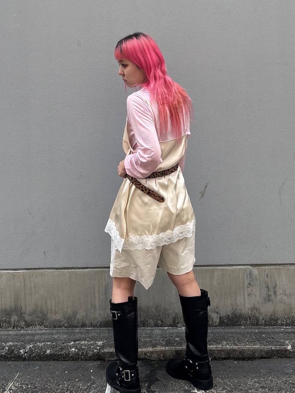 ブラック系のブーツ、ホワイト系のスラックス、ホワイト系のキャミソールを着用したレディースの春コーディネートの3枚目の写真