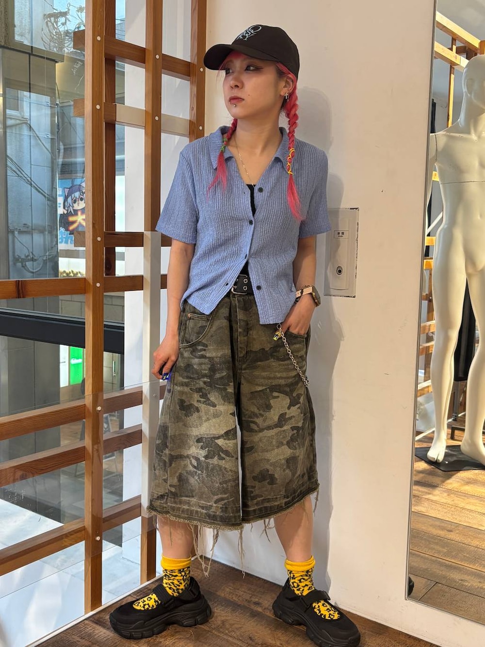 グリーン系のデニムパンツ、ブルー系のポロシャツ、ブラック系のタンクトップを着用したレディースの夏コーディネートの4枚目の写真