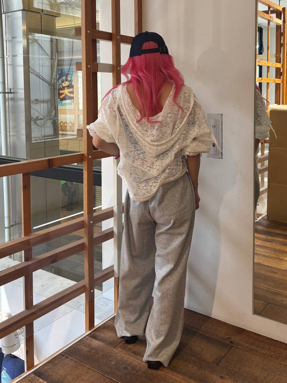 ホワイト系のパーカー、グレー系のスウェットパンツ、ブルー系のキャップを着用したレディースの夏コーディネートの5枚目の写真