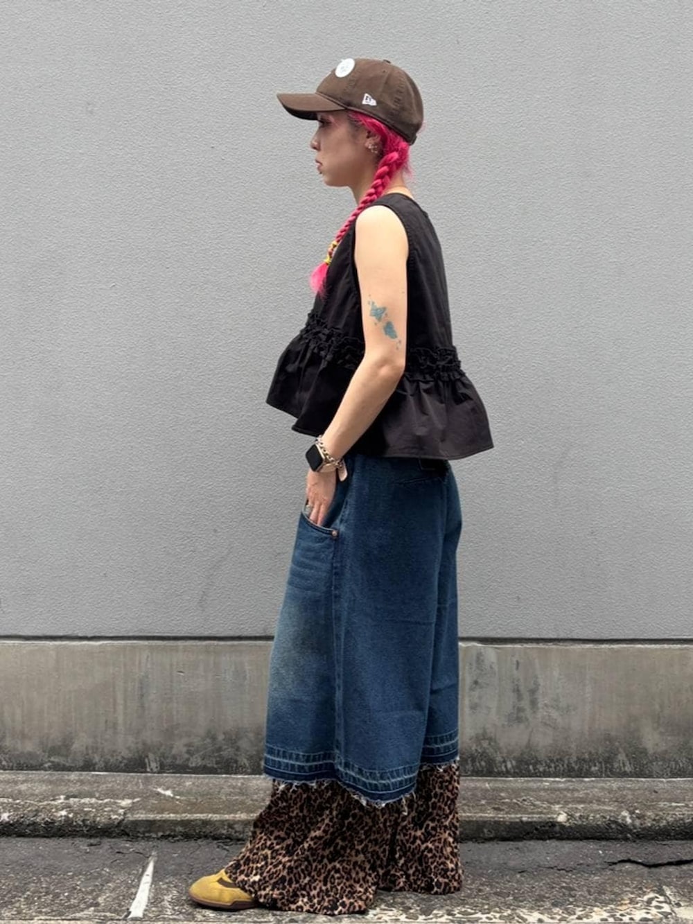 ブルー系のデニムパンツ、ブラック系のタンクトップ、ブラック系のベストを着用したレディースの夏コーディネートの5枚目の写真