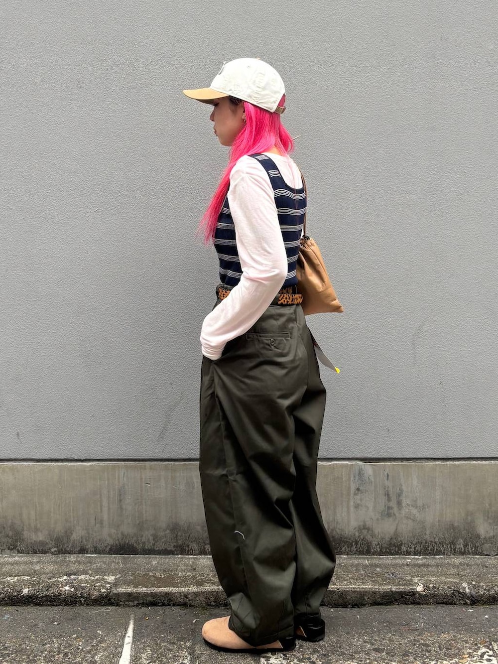 ベージュ系のショルダーバッグ、グリーン系のチノパンツ、ベージュ系のモカシン/デッキシューズを着用したレディースの春コーディネートの5枚目の写真