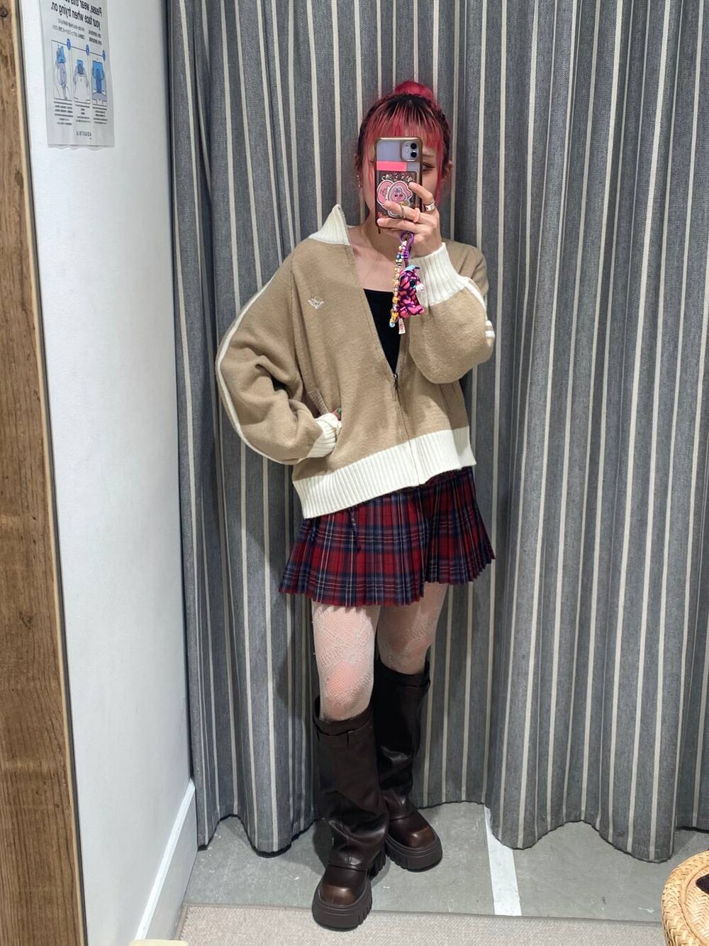 ブラック系のキャミソール、ブラウン系のブーツ、レッド系のスカートを着用したレディースの秋コーディネートの2枚目の写真