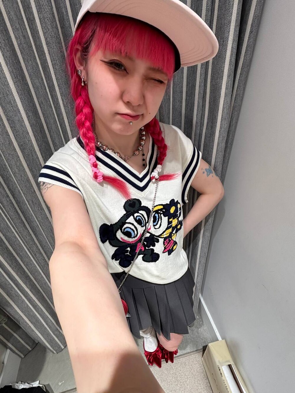 レッド系のサンダル、グレー系のスカート、レッド系のショルダーバッグを着用したレディースの春コーディネートの2枚目の写真