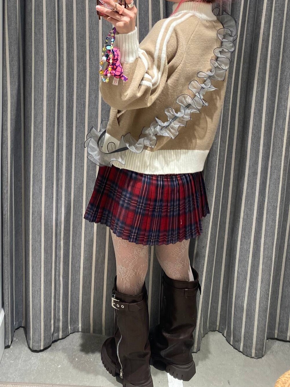 ブラック系のキャミソール、ブラウン系のブーツ、レッド系のスカートを着用したレディースの秋コーディネートの3枚目の写真