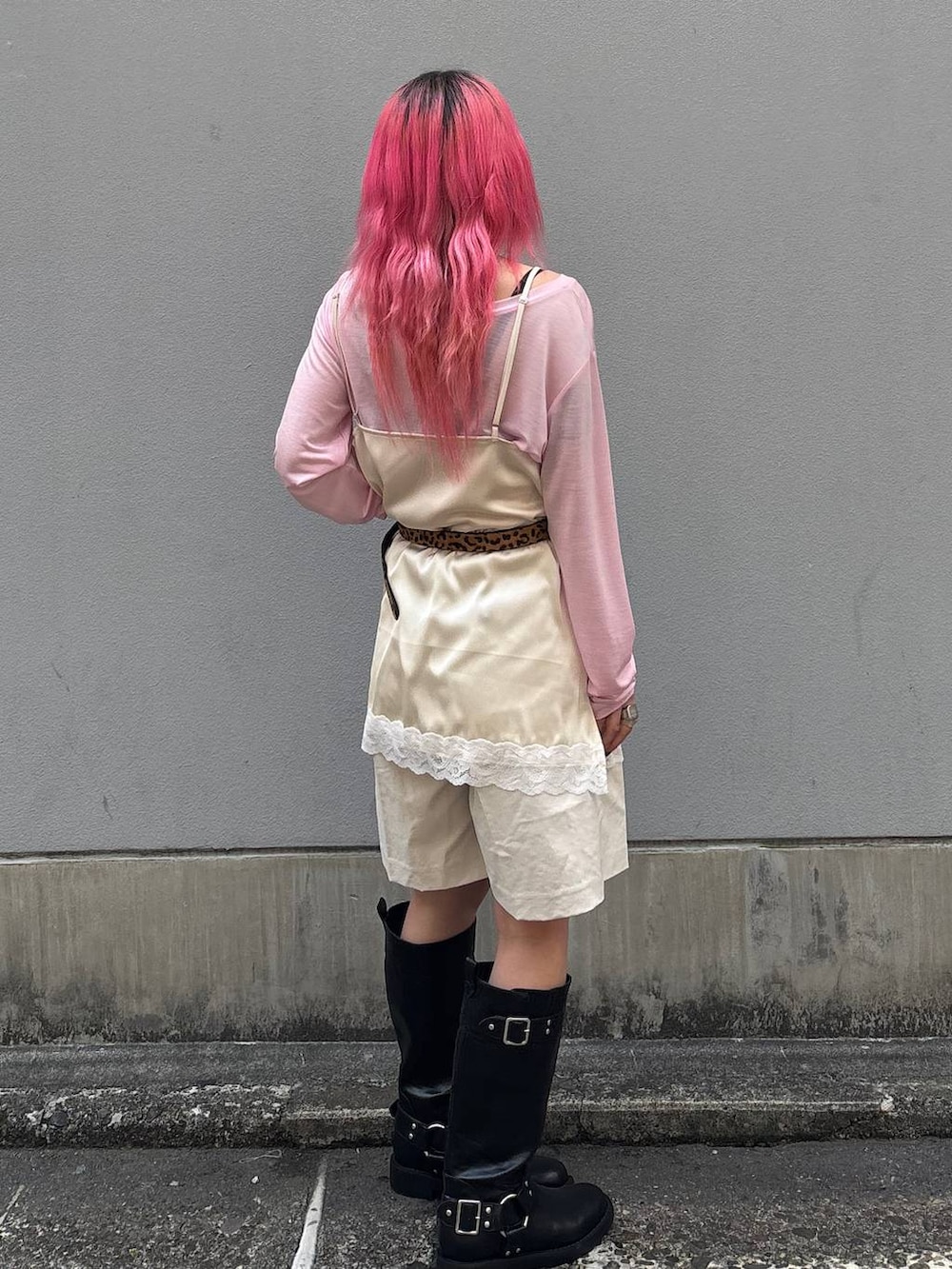 ブラック系のブーツ、ホワイト系のスラックス、ホワイト系のキャミソールを着用したレディースの春コーディネートの4枚目の写真