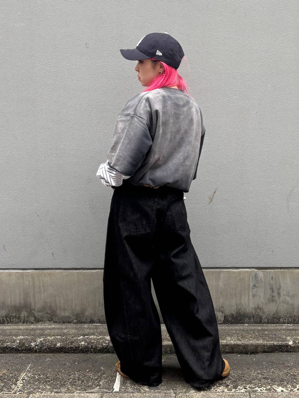 ホワイト系のTシャツ/カットソー、ブラック系のデニムパンツ、ブルー系のキャップを着用したレディースの春コーディネートの3枚目の写真