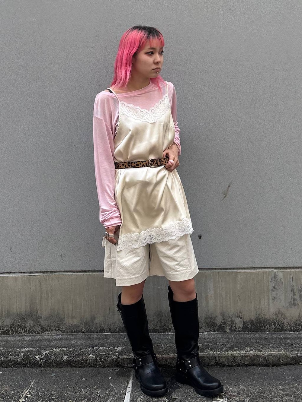 ブラック系のブーツ、ホワイト系のスラックス、ホワイト系のキャミソールを着用したレディースの春コーディネートの6枚目の写真