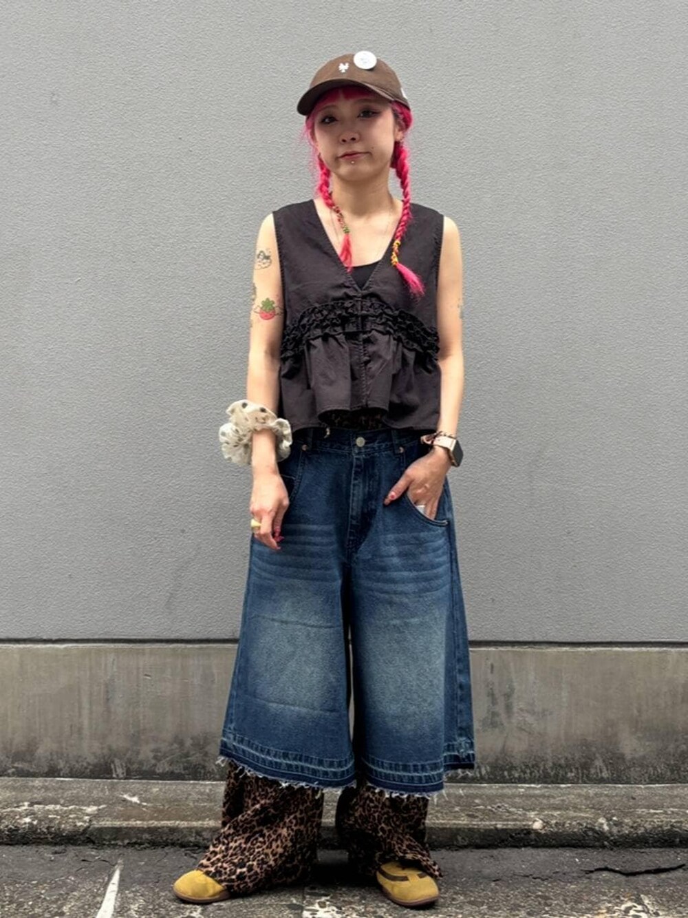 ブルー系のデニムパンツ、ブラック系のタンクトップ、ブラック系のベストを着用したレディースの夏コーディネートの7枚目の写真