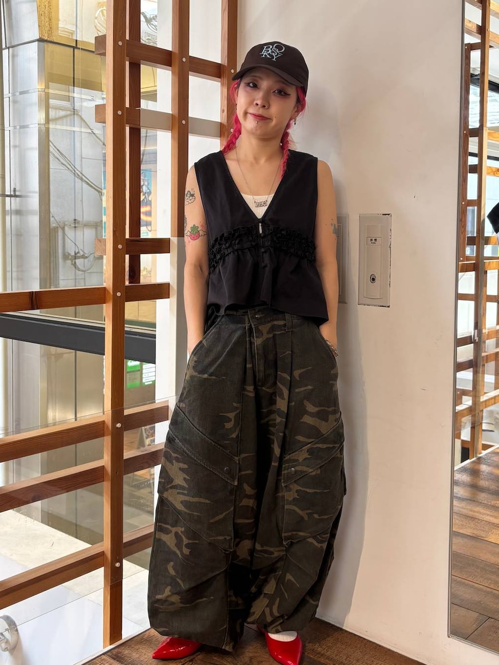 レッド系のパンプス、ホワイト系のタンクトップ、グリーン系のその他パンツを着用したレディースの夏コーディネートの3枚目の写真
