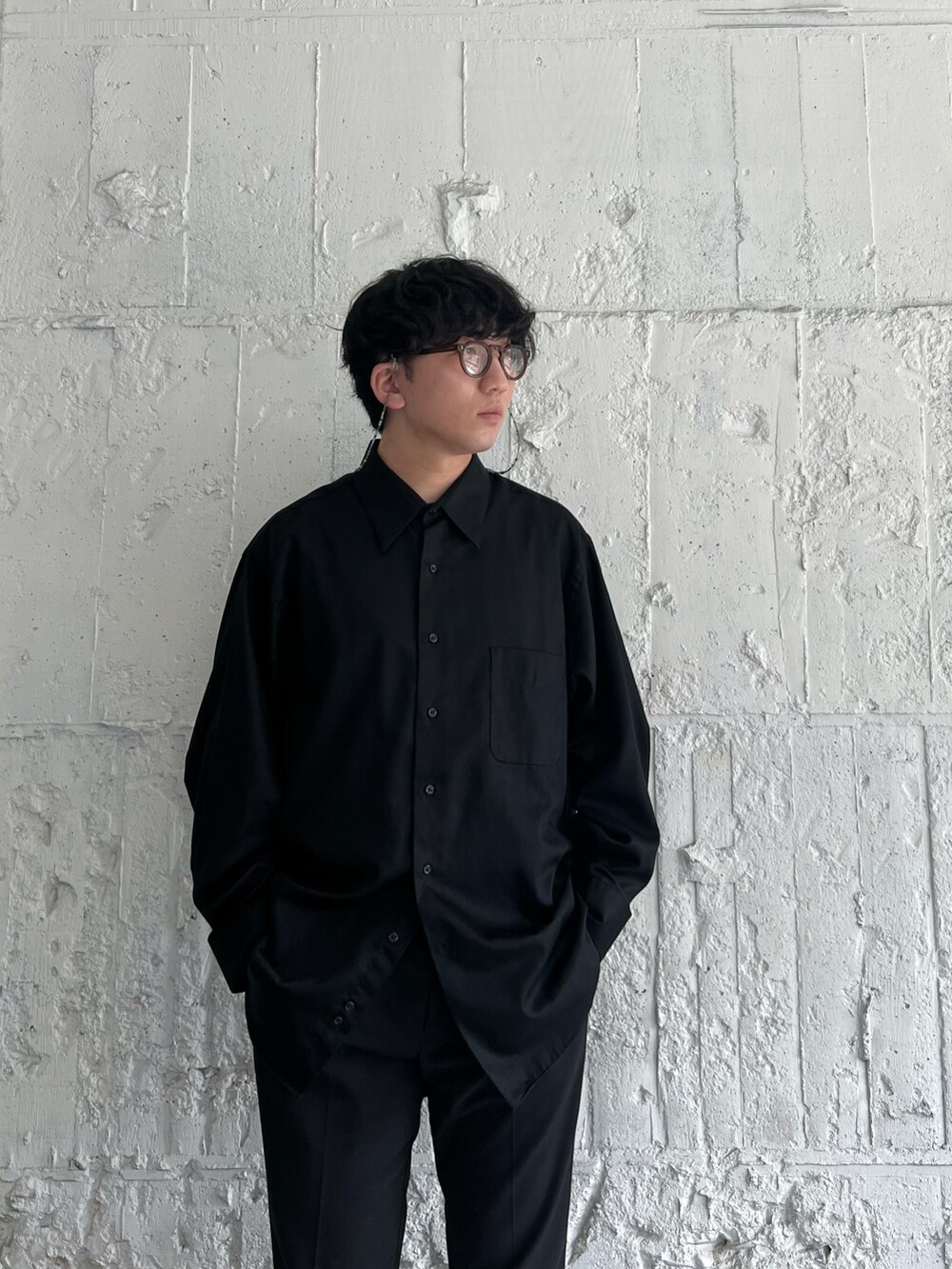 ブラック系のスラックス、ホワイト系のスニーカー、ブラック系のシャツ/ブラウスを着用したメンズの秋コーディネートの5枚目の写真