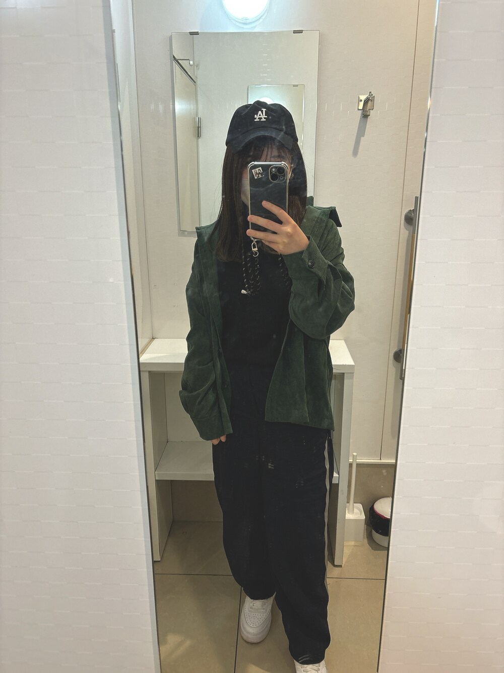 ブラック系のパンツ、グリーン系のシャツ/ブラウス、ブラック系のニット/セーターを着用したレディースの春コーディネートの2枚目の写真