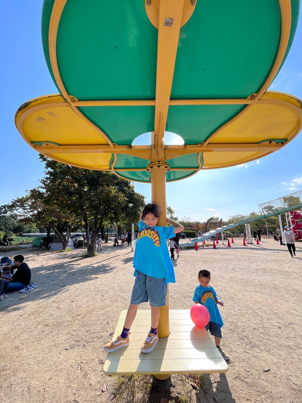 ブルー系のチュニック、ブルー系のチュニック、オレンジ系のスニーカーを着用したキッズの春コーディネートの4枚目の写真