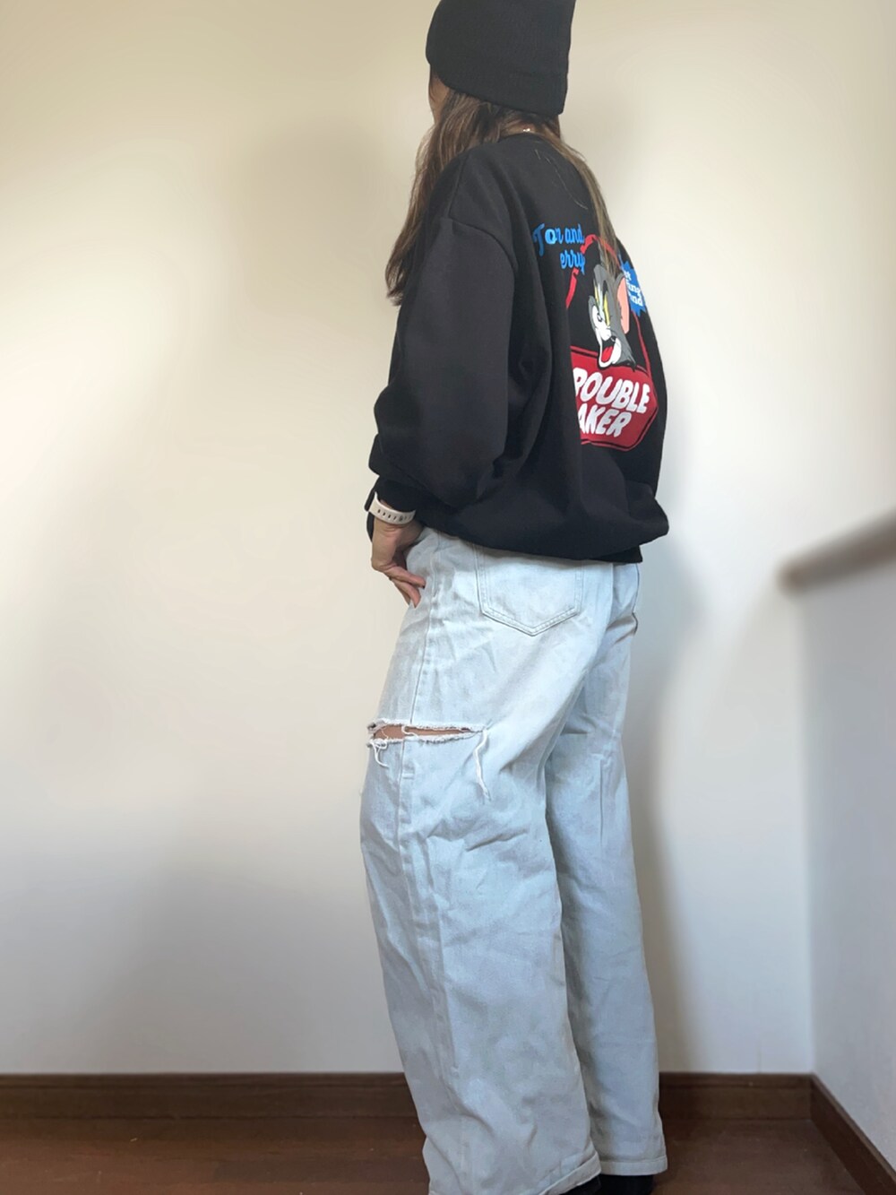 ブラック系のスウェット、ブルー系のデニムパンツ、ブラック系のブーツを着用したレディースの冬コーディネートの3枚目の写真