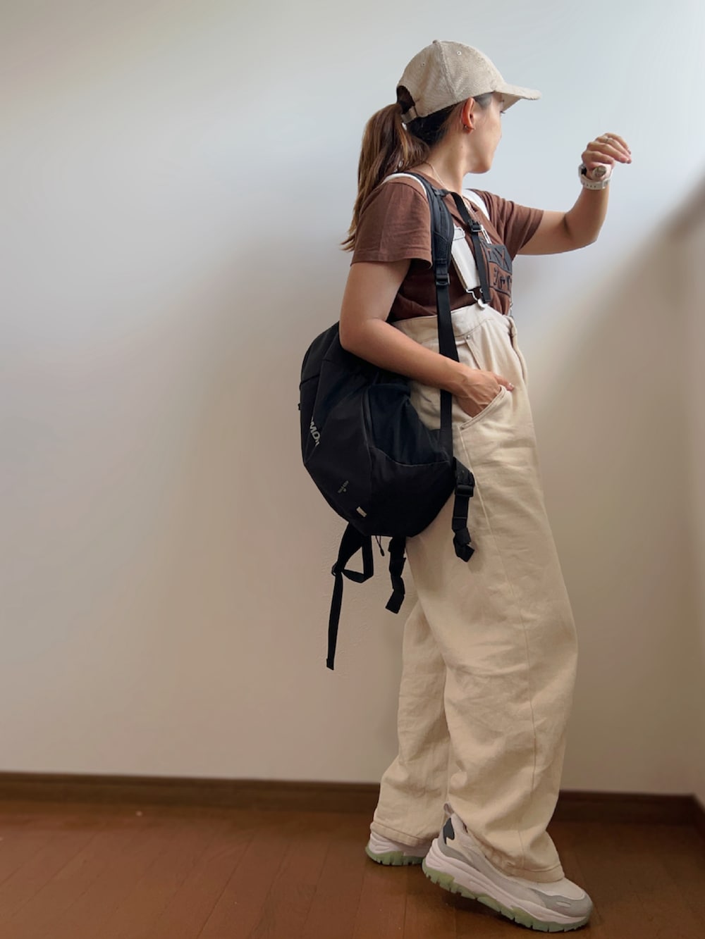 ブラウン系のTシャツ/カットソー、ブラック系のバックパック/リュック、ホワイト系のサロペット/オーバーオールを着用したレディースの秋コーディネートの3枚目の写真