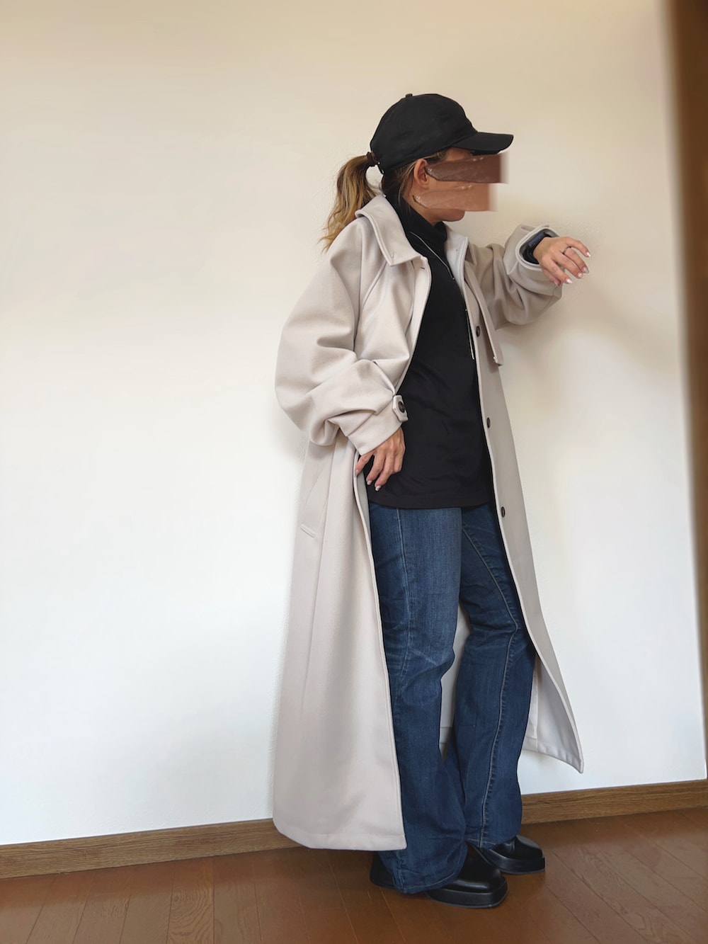 ブラック系のその他トップス、ホワイト系のチェスターコート、ブルー系のデニムパンツを着用したレディースの冬コーディネートの3枚目の写真