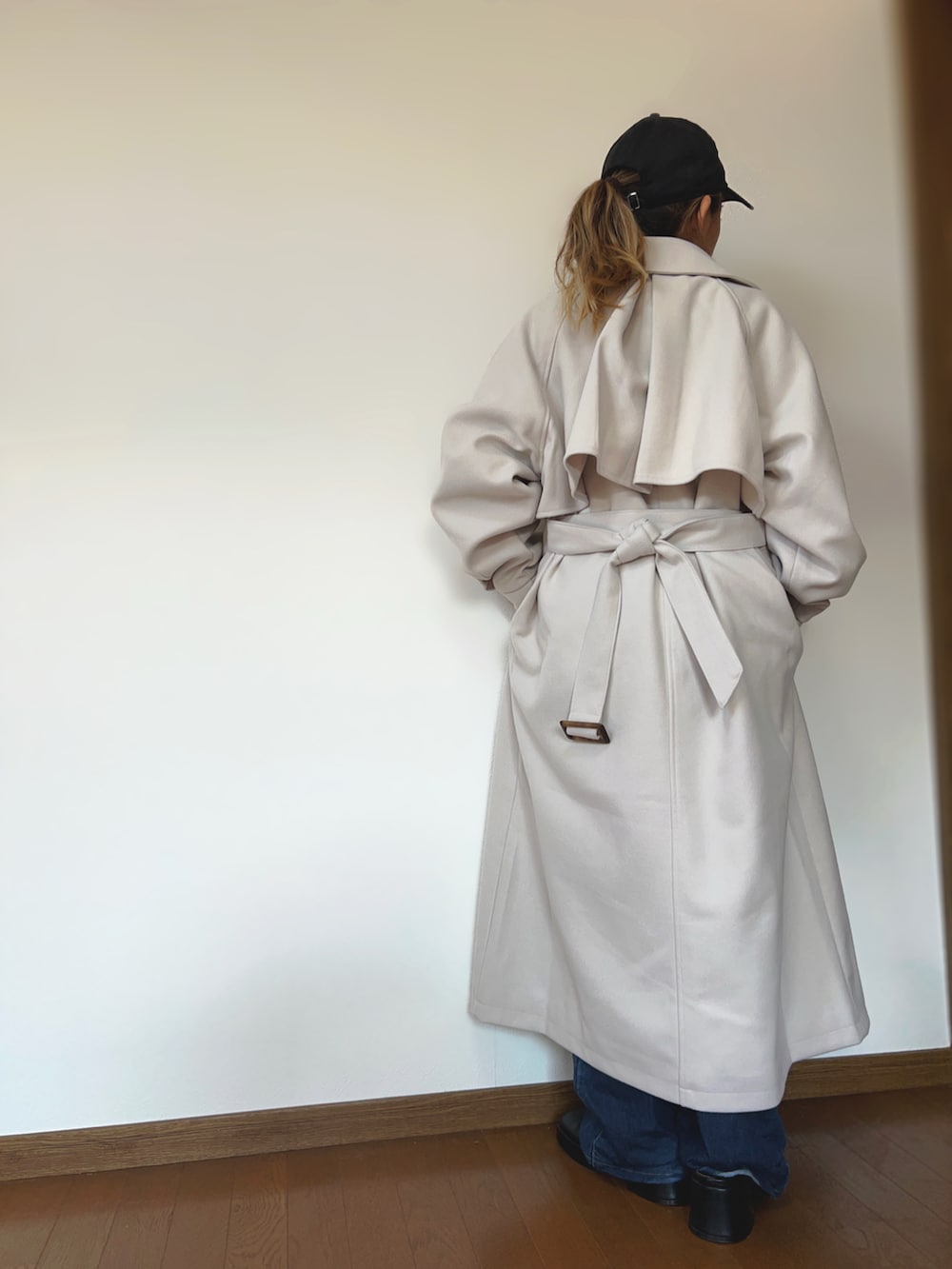 ブラック系のその他トップス、ホワイト系のチェスターコート、ブルー系のデニムパンツを着用したレディースの冬コーディネートの4枚目の写真