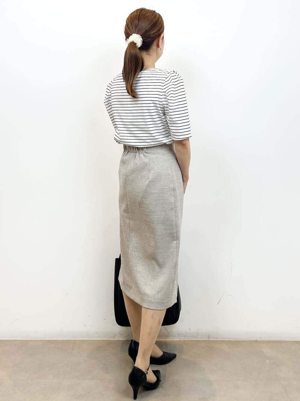 ホワイト系のTシャツ/カットソー、ベージュ系のスカート、ブラック系のトートバッグを着用したレディースの夏コーディネートの7枚目の写真