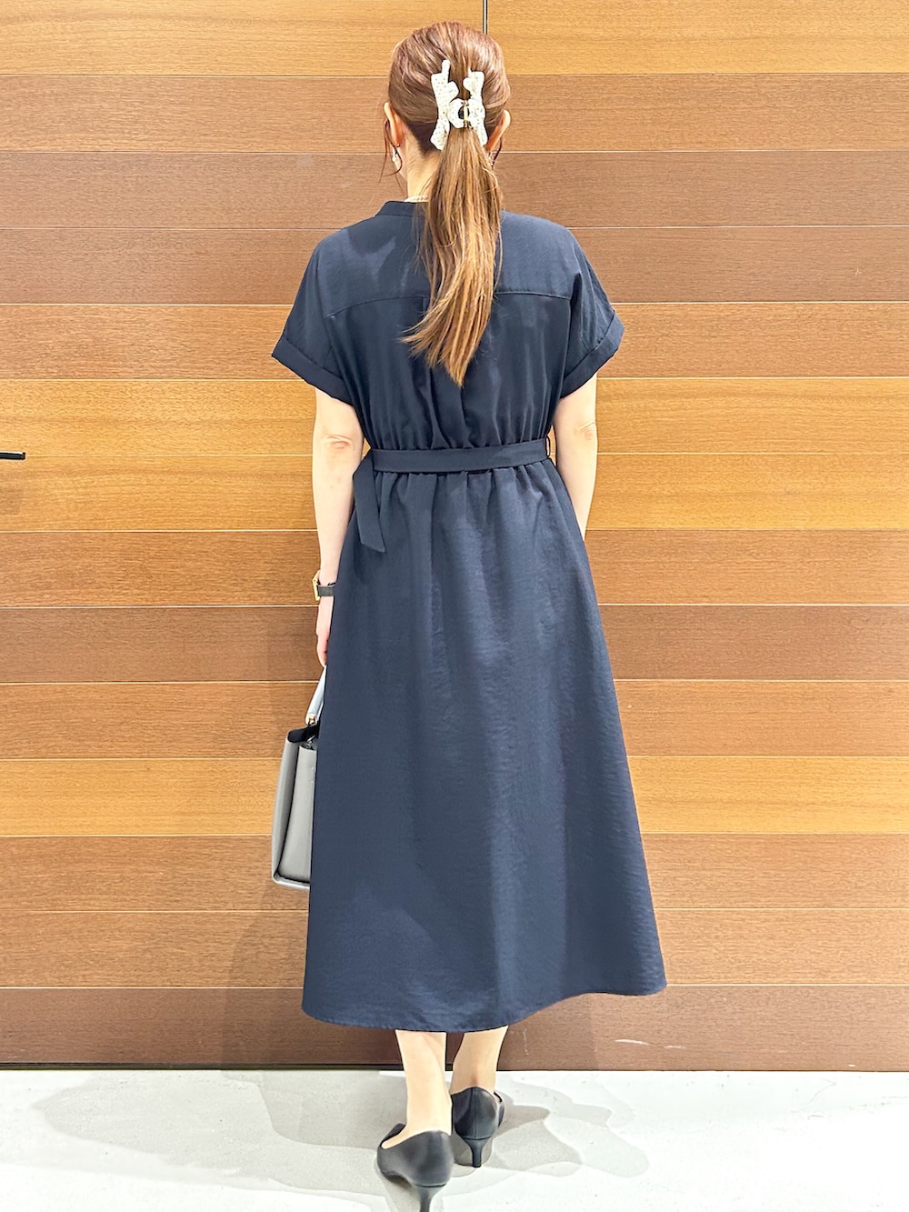 ブルー系のワンピース、ベージュ系のトートバッグ、ブラック系のパンプスを着用したレディースの夏コーディネートの6枚目の写真