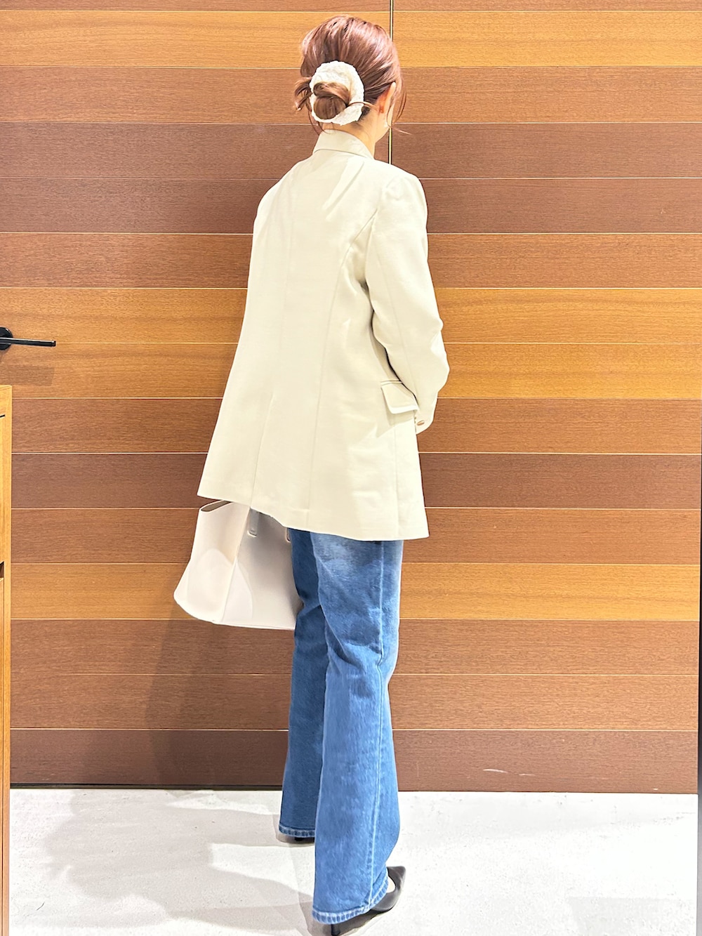 ブルー系のデニムパンツ、ホワイト系のショルダーバッグ、ブラック系のパンプスを着用したレディースの春コーディネートの7枚目の写真