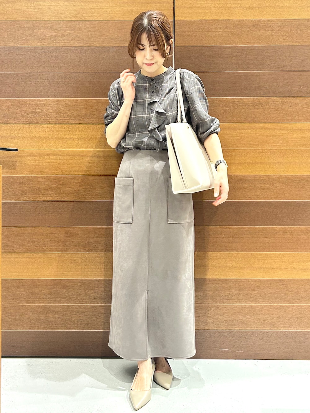 グレー系のシャツ/ブラウス、ベージュ系のトートバッグ、ベージュ系のパンプスを着用したレディースの秋コーディネートの2枚目の写真