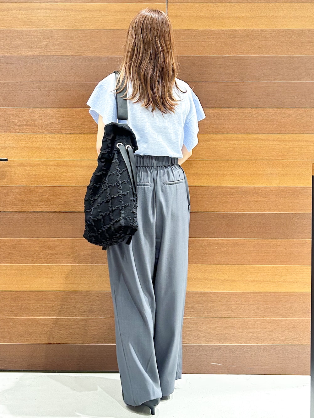 ブルー系のニット/セーター、グレー系のその他パンツ、ブラック系のトートバッグを着用したレディースの夏コーディネートの6枚目の写真