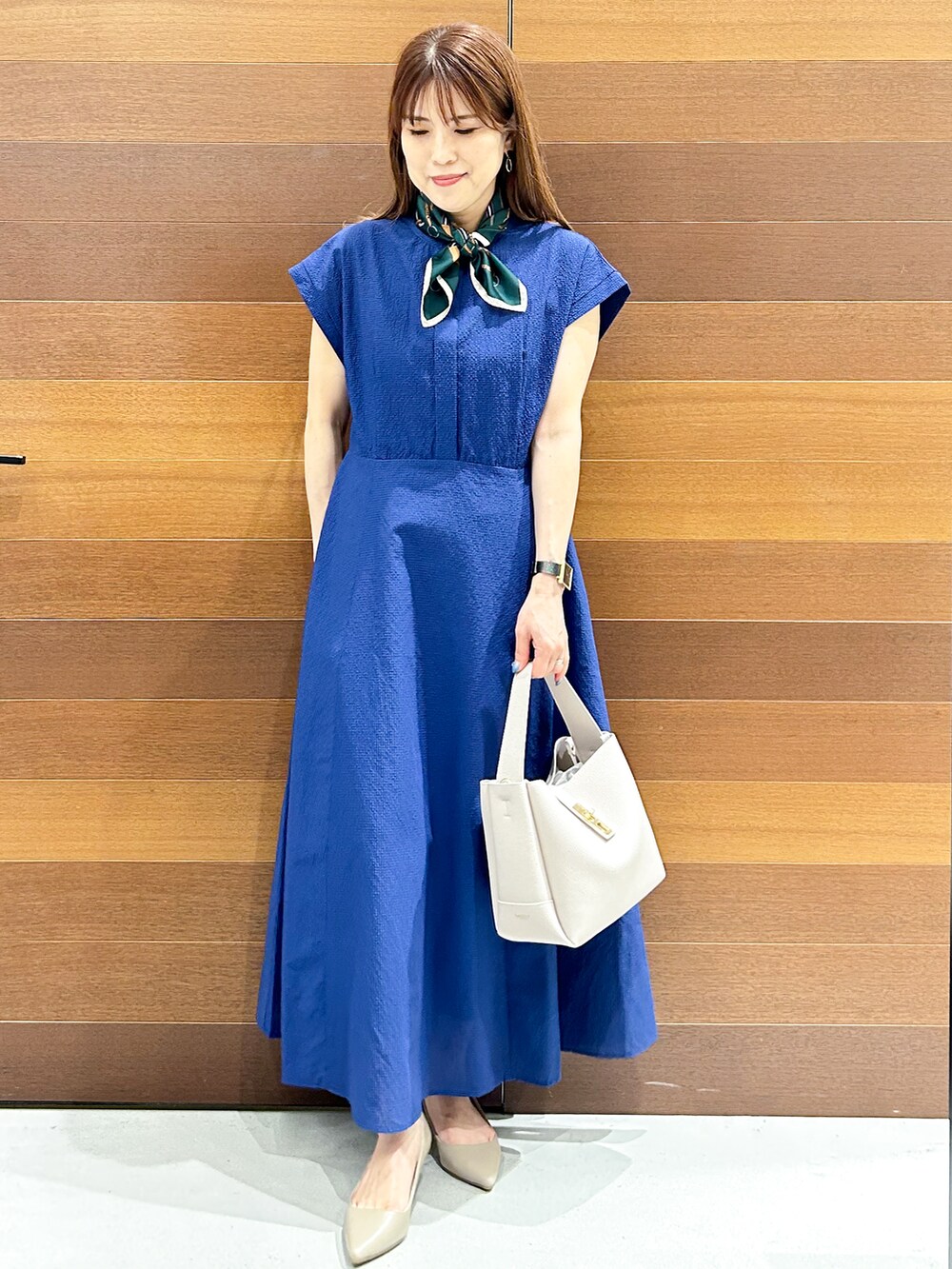 ブルー系のワンピース、グレー系のトートバッグ、ベージュ系のパンプスを着用したレディースの夏コーディネートの2枚目の写真