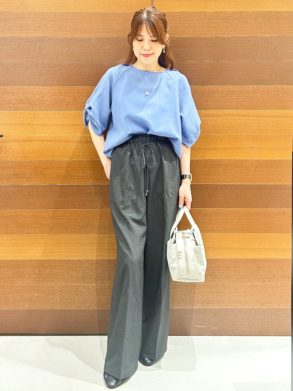 ブルー系のシャツ/ブラウス、グレー系のその他パンツ、グレー系のボストンバッグを着用したレディースの夏コーディネートの3枚目の写真