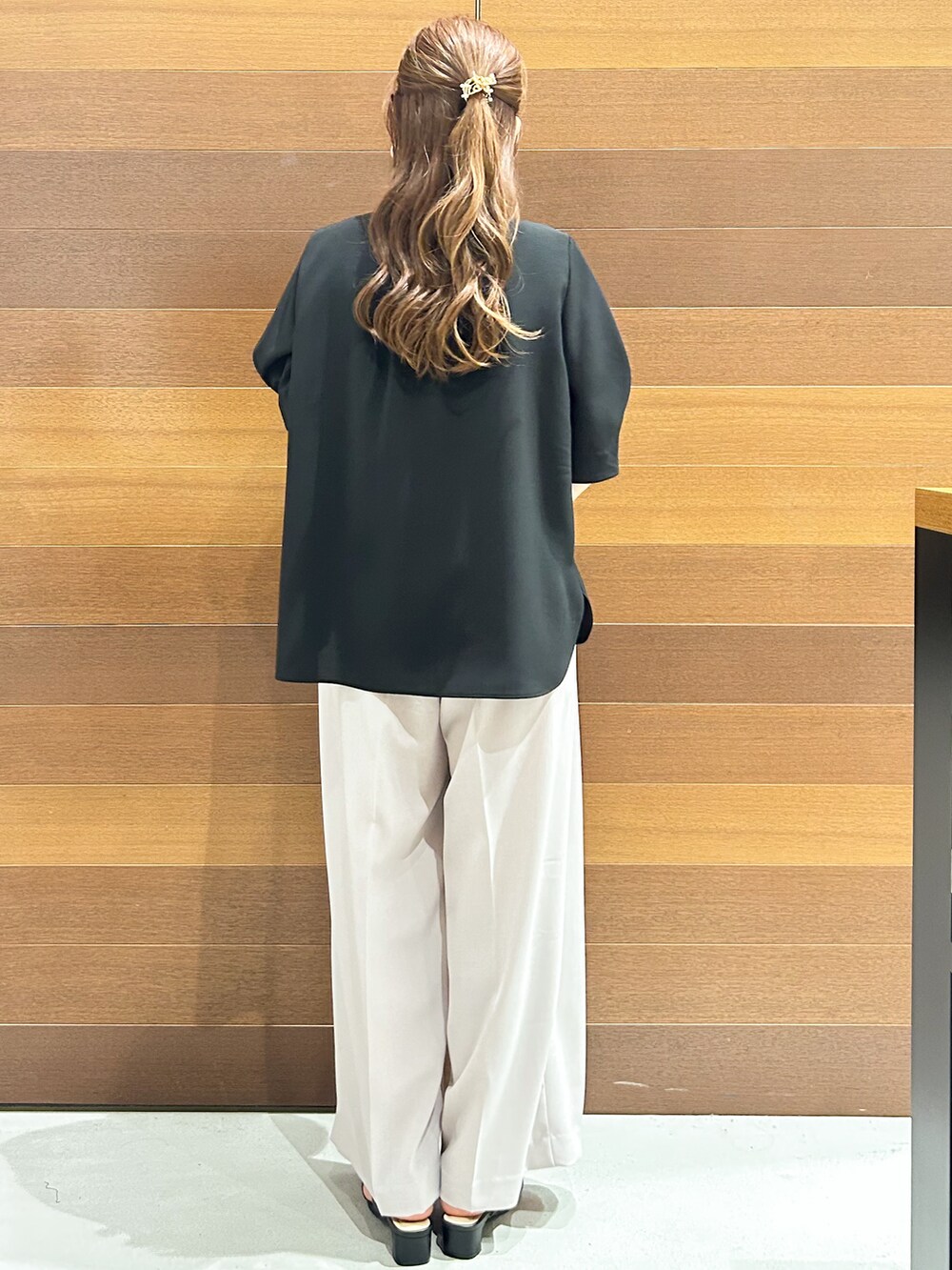 ブラック系のシャツ/ブラウス、ベージュ系のその他パンツ、ブラック系のハンドバッグを着用したレディースの春コーディネートの4枚目の写真