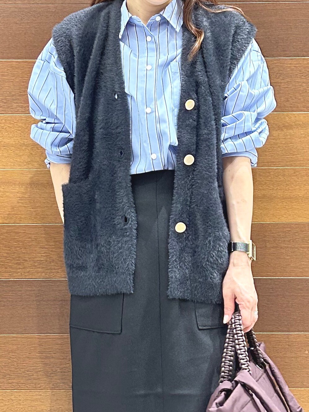 グレー系のニット/セーター、ブルー系のシャツ/ブラウス、ブラック系のスカートを着用したレディースの秋コーディネートの9枚目の写真