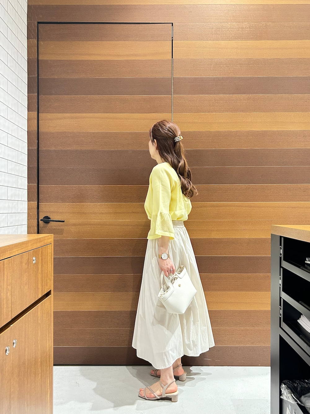 ベージュ系のスカート、ベージュ系のサンダル、ベージュ系のトートバッグを着用したレディースの春コーディネートの5枚目の写真