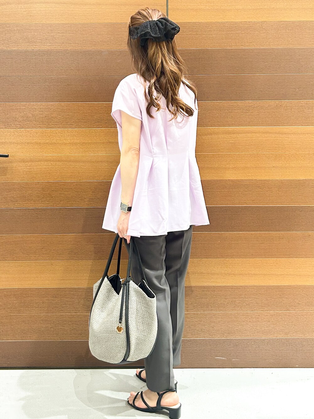 グレー系のその他パンツ、ブラック系のサンダル、グレー系のトートバッグを着用したレディースの春コーディネートの6枚目の写真
