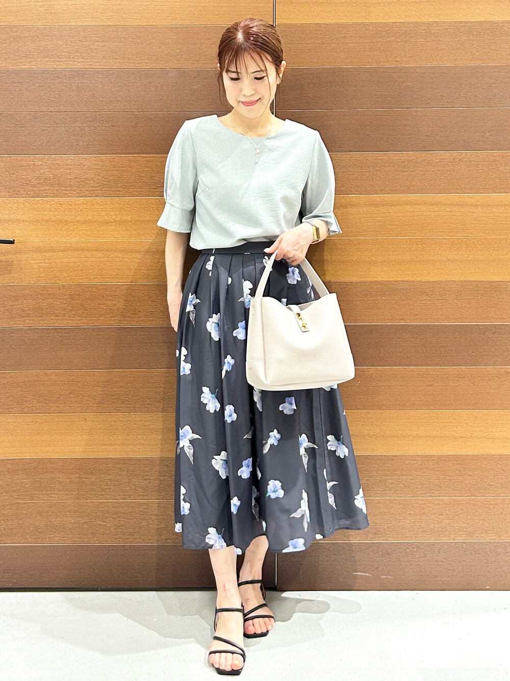 グリーン系のシャツ/ブラウス、グレー系のスカート、グレー系のトートバッグを着用したレディースの夏コーディネートの4枚目の写真