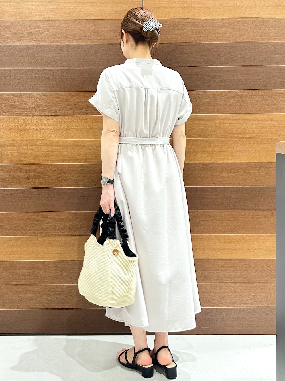ベージュ系のワンピース、ブラック系のトートバッグ、ブラック系のサンダルを着用したレディースの夏コーディネートの5枚目の写真
