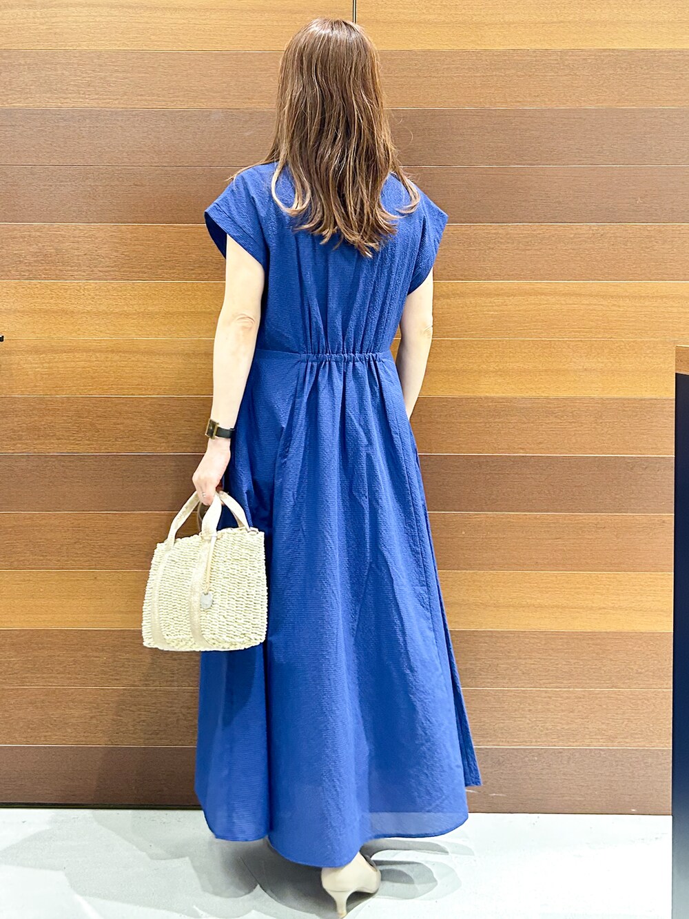 ブルー系のワンピース、ベージュ系のトートバッグ、ベージュ系のパンプスを着用したレディースの夏コーディネートの5枚目の写真