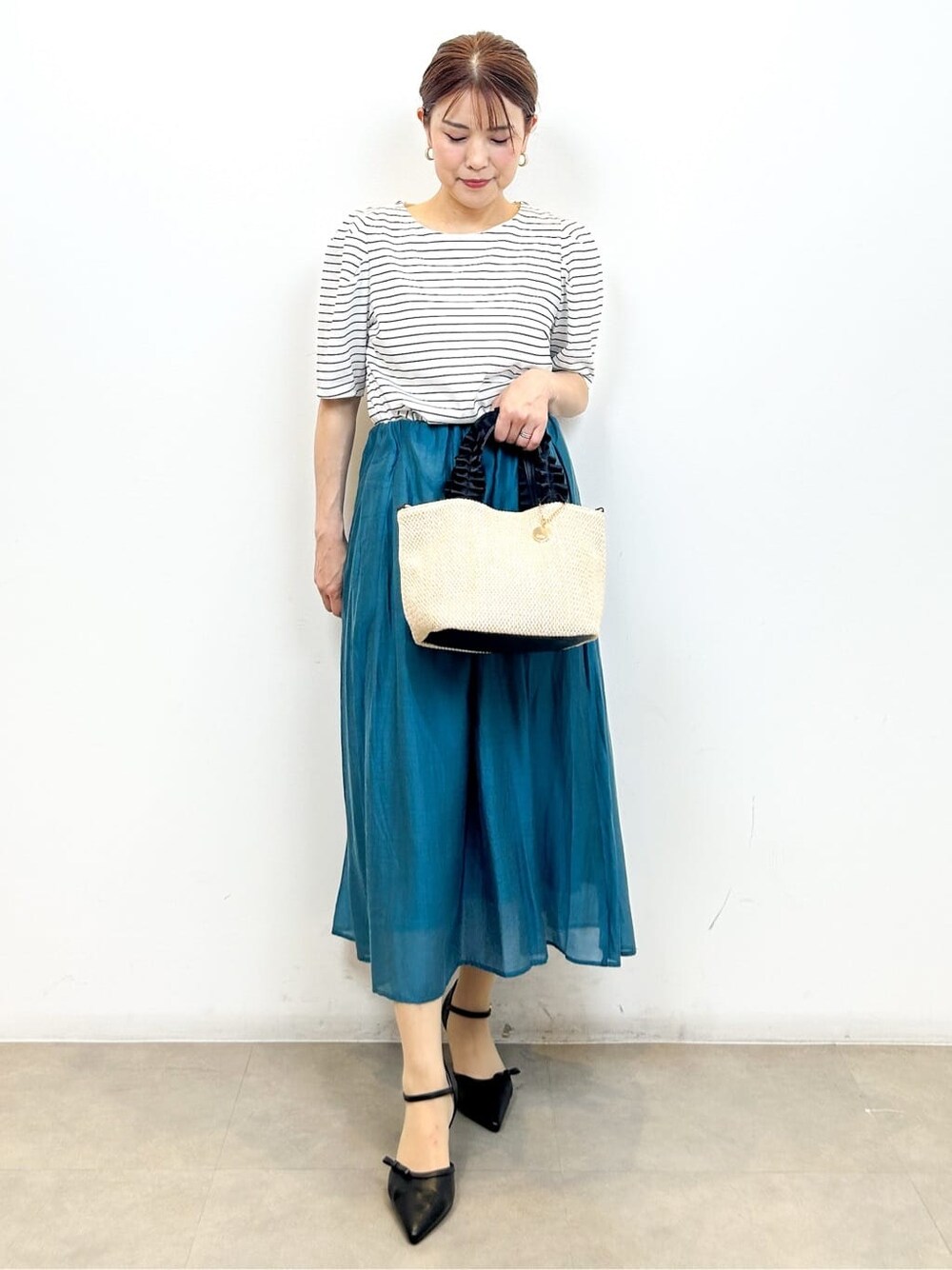 ホワイト系のTシャツ/カットソー、ブルー系のスカート、ブラック系のトートバッグを着用したレディースの夏コーディネートの3枚目の写真