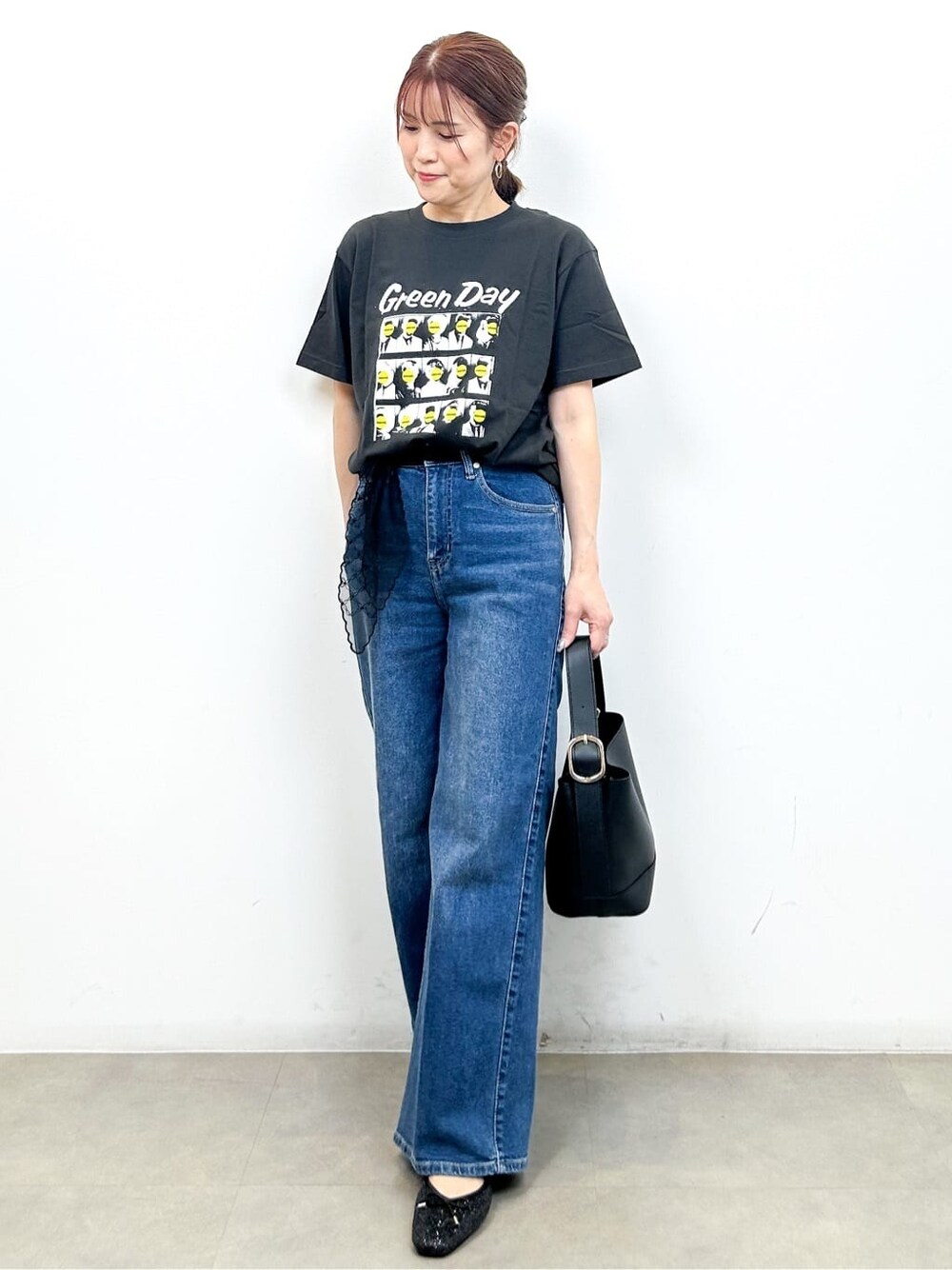 グレー系のTシャツ/カットソー、ブルー系のデニムパンツ、ブラック系のショルダーバッグを着用したレディースの秋コーディネートの3枚目の写真