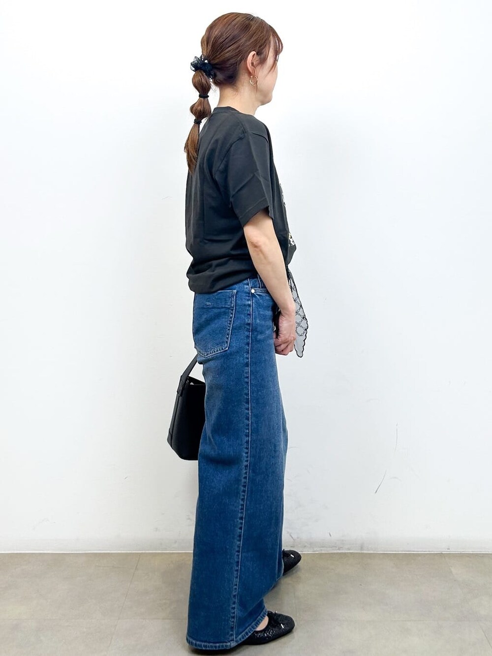 グレー系のTシャツ/カットソー、ブルー系のデニムパンツ、ブラック系のショルダーバッグを着用したレディースの秋コーディネートの9枚目の写真
