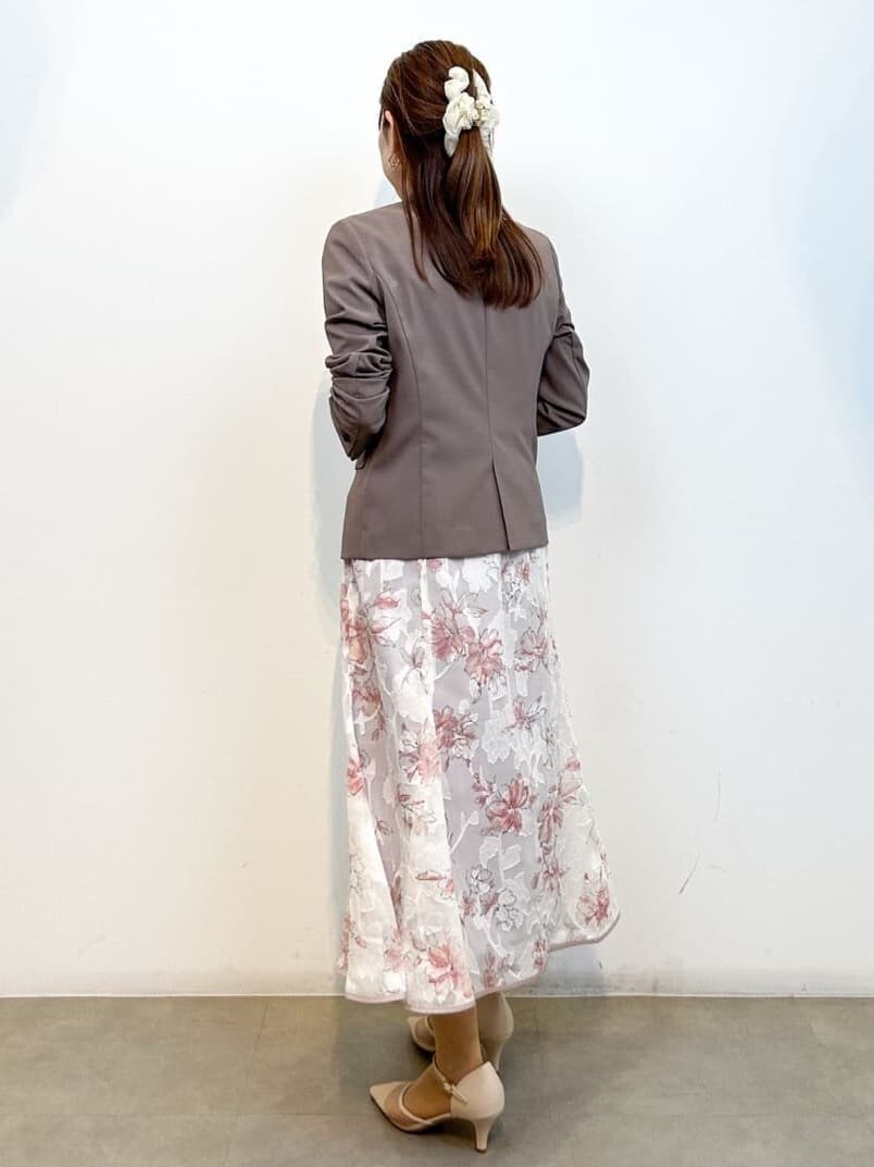 ブラウン系のテーラードジャケット、ホワイト系のTシャツ/カットソー、ベージュ系のスカートを着用したレディースの春コーディネートの5枚目の写真