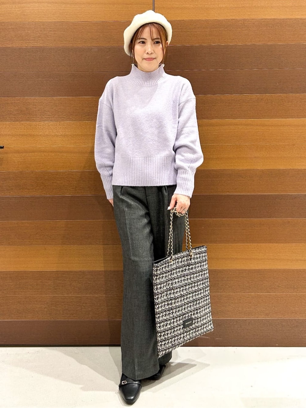 パープル系のニット/セーター、グレー系のその他パンツ、ブラック系のトートバッグを着用したレディースの冬コーディネートの2枚目の写真