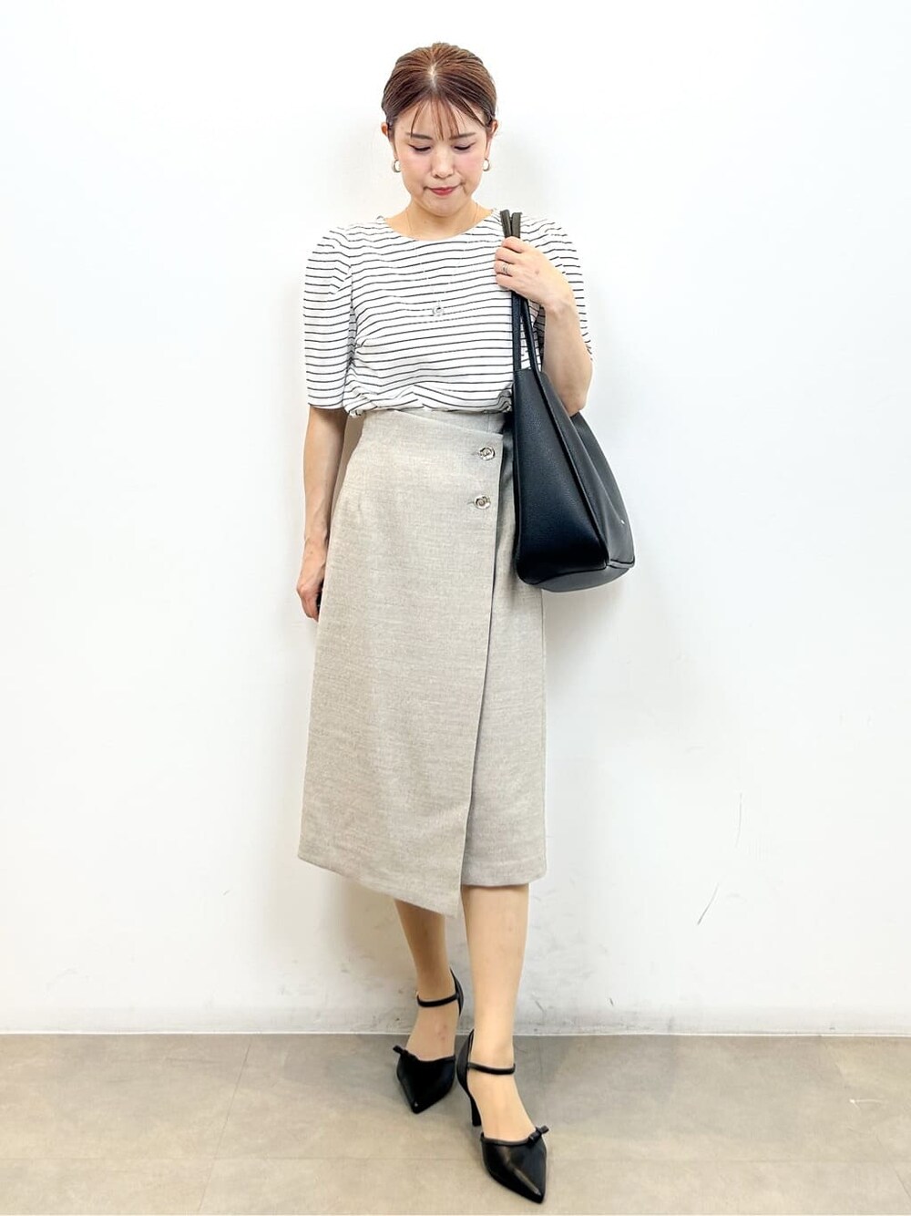 ホワイト系のTシャツ/カットソー、ベージュ系のスカート、ブラック系のトートバッグを着用したレディースの夏コーディネートの9枚目の写真