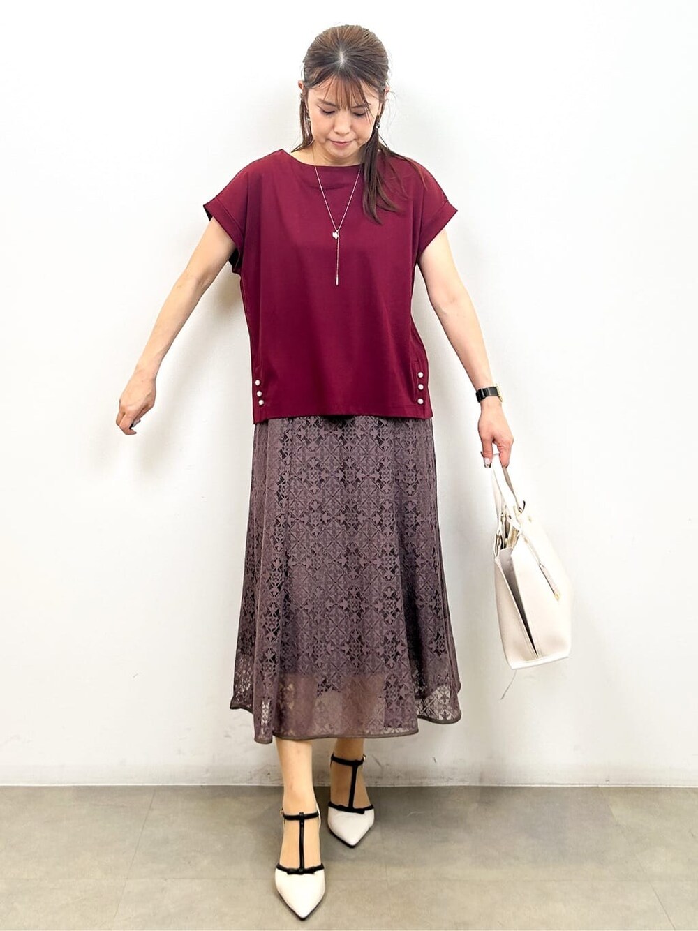 レッド系のTシャツ/カットソー、ブラウン系のスカート、ベージュ系のトートバッグを着用したレディースの夏コーディネートの2枚目の写真