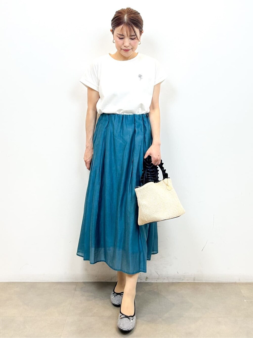 ホワイト系のTシャツ/カットソー、ブルー系のスカート、ブラック系のトートバッグを着用したレディースの夏コーディネートの5枚目の写真